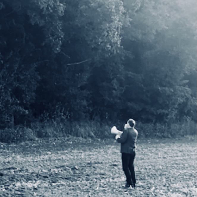 Personne avec porte-voix face à la forêt